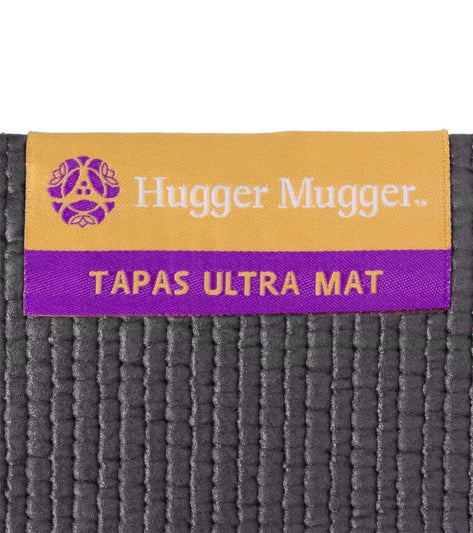 Hugger Mugger Tapas Ultra Mat in Slate color, designed for yoga practice. The mat features a textured surface for enhanced grip and stability. Ideal for yogis seeking durability and comfort in their yoga sessions.