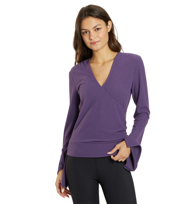 Thrive Societe Women's Yoga Wrap in Loganberry, designed for yoga enthusiasts. This stylish wrap features a deep V-neck and long sleeves, perfect for comfortable movement during workouts. Ideal for adding a pop of color to your yoga wardrobe.