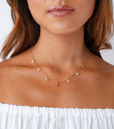 Lotus and Luna Yoga Necklace featuring delicate Mother of Pearl charms on a gold chain, designed for yoga enthusiasts. The necklace showcases a blend of soothing colors, perfect for enhancing mindfulness and style. Ideal for those seeking a balance of elegance and spirituality in their