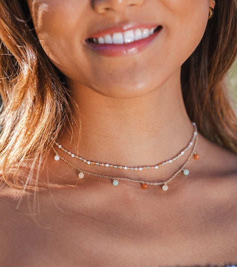 Lotus and Luna Yoga Necklace featuring delicate beads and Mother of Pearl accents, perfect for enhancing your yoga practice. This elegant necklace combines style and spirituality, ideal for mindful meditation and fashion-forward yogis.