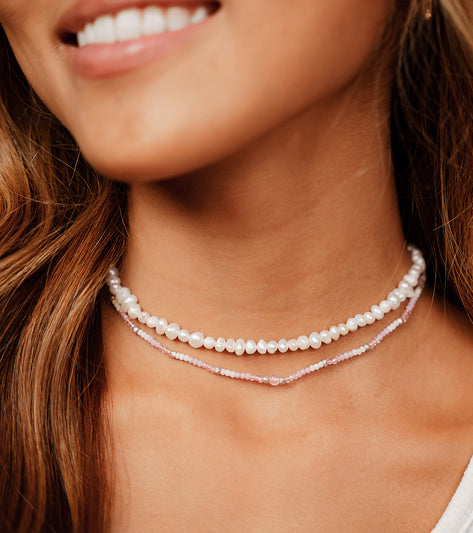 Lotus and Luna yoga necklace featuring elegant strands of pearls and rose quartz beads. This handcrafted jewelry piece is perfect for enhancing your yoga practice with its calming and stylish design. Ideal for those seeking spiritual balance and beauty in their accessories.